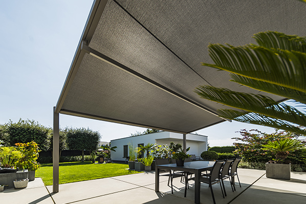 Store screen Renson filtrant la lumière sur une terrasse